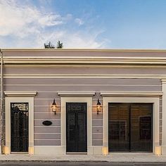 an empty street in front of a building with two doors and three windows on each side