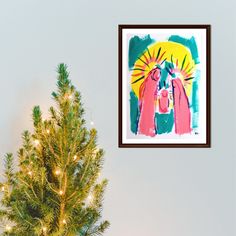 a christmas tree in front of a painting on the wall and a small pine tree