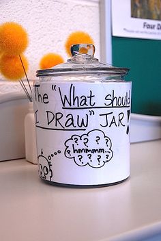 a white can with writing on it sitting on top of a counter next to a yellow pom - pom