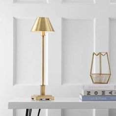 a white table topped with books and a lamp