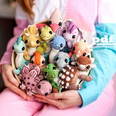 a person holding a basket full of small crocheted animal toys in their hands