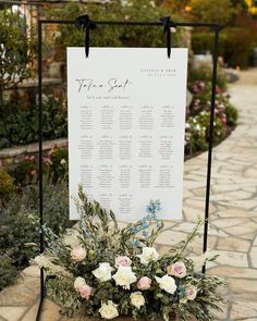 a table plan is set up with flowers and greenery for an outdoor wedding ceremony