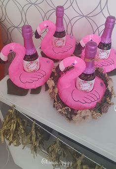 pink flamingo shaped wine bottles sitting on top of a table next to other items