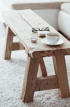 a coffee table with a magazine and cup on it