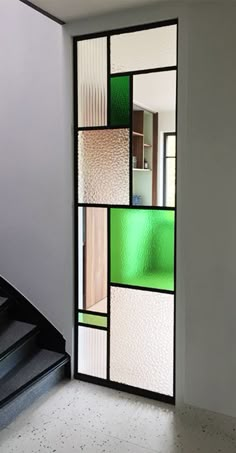 an open door with multiple colored glass panels on the front and back doors, along with a stair case