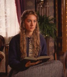 a woman sitting in a chair reading a book