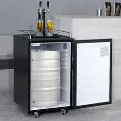 an open refrigerator with drinks in it sitting next to a sink and counter top on wheels