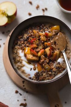 a bowl of oatmeal with apples and granola