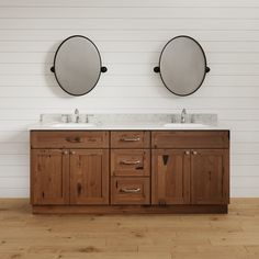 two round mirrors are above the double sink vanity