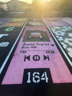 the sun is shining over a parking lot that has been painted with various colors and numbers