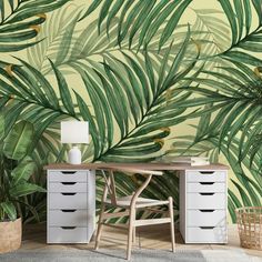 a room with a palm tree wallpaper and white drawers in front of the desk