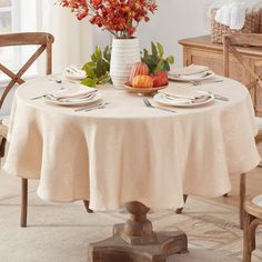 the table is set with plates, silverware and flowers in a vase on it