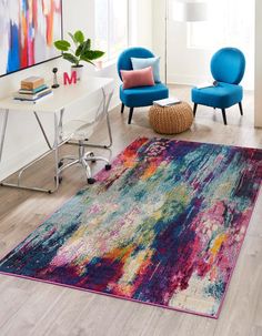 a living room with two blue chairs and a colorful rug on the floor in front of a window