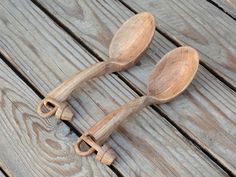 two wooden spoons sitting on top of a wooden table