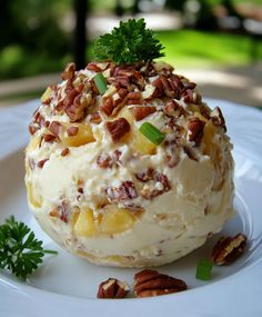 a white plate topped with ice cream covered in nuts and toppings on top of it