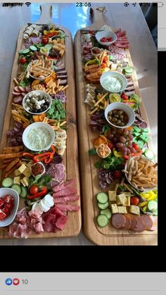 two wooden trays filled with different types of food on top of a table next to each other