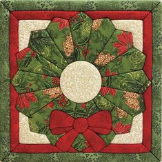 a quilted christmas wreath with red bows and green leaves on the center is shown