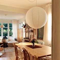 a living room filled with furniture and a wooden table in front of a large window