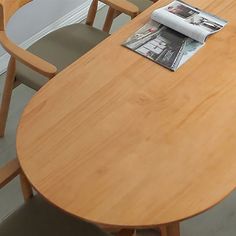 a wooden table with two chairs and a magazine on it