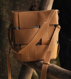 a brown leather bag sitting on top of a wooden pole