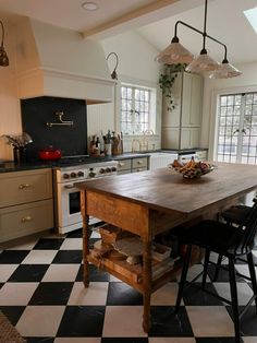 a kitchen with black and white checkered flooring and an island table in the middle