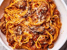 a white bowl filled with spaghetti and meat sauce