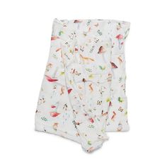 two baby swaddles with colorful birds and leaves on them, one is white