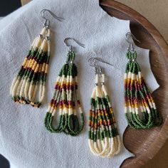 three pairs of beaded earrings sitting on top of a white towel