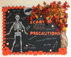 a halloween bulletin board with a skeleton and pumpkins on it, surrounded by fall leaves