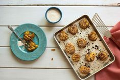 a blue plate topped with muffins next to a bowl of yogurt