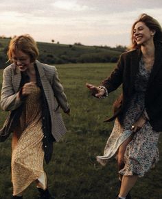 two women are walking in the grass together