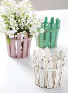 three small pots with flowers in them sitting on a table