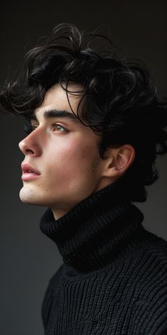 a young man with curly hair wearing a black turtle neck sweater looking off to the side