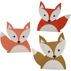 four paper fox heads are shown in three different colors