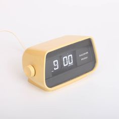 an alarm clock with the time nine o'clock in yellow on a white background