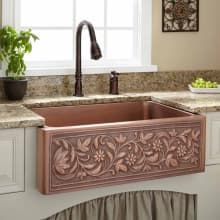 a kitchen sink with an ornate design on the front and side, under a window