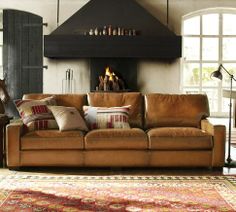 a living room filled with furniture and a fire place in the middle of the room