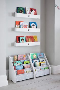 the bookshelves are organized with white plastic bins for children's books