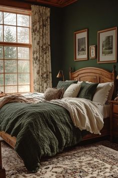 a bed with green comforter and pillows in a bedroom next to a large window