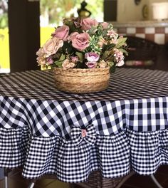 a basket filled with flowers sitting on top of a checkered tablecloth covered table