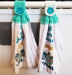 two towels hanging on the side of an oven door with buttons and words written on them