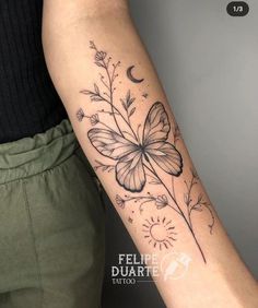 a woman's arm with a butterfly and flower tattoo on the left side of her arm