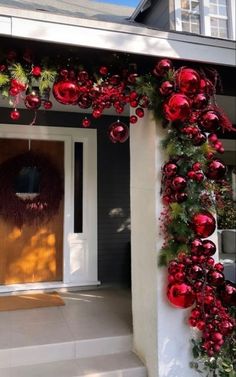 a house decorated for christmas with red ornaments and greenery