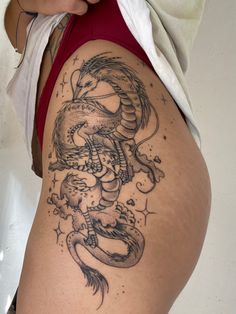 a woman with a dragon tattoo on her thigh