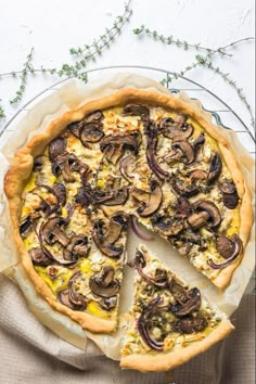 a mushroom and cheese quiche on a plate with one slice missing from the pie