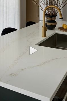 a white counter top in a kitchen next to a sink