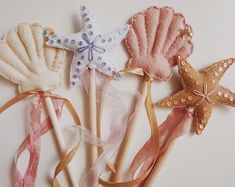 four seashells and starfish on sticks with ribbons