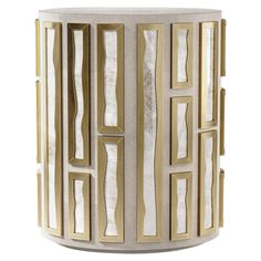 a white and gold side table with geometric designs on the top, in front of a white background