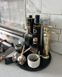 Unlacquered brass salt and pepper mills wirh gourmet oil and vinegar and seasoned salts. Countertop styling. Marble tile backsplash Kitchen Oils Organization, Oil And Vinegar Kitchen Decor, Kitchen Counter Olive Oil, Salt Pepper Oil Tray, Brass Pepper Mill Styling, Carnival Cottage, Brass Salt And Pepper Mill, Counter Styling