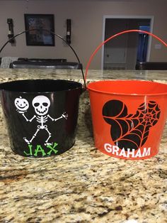 two halloween buckets sitting on top of a counter